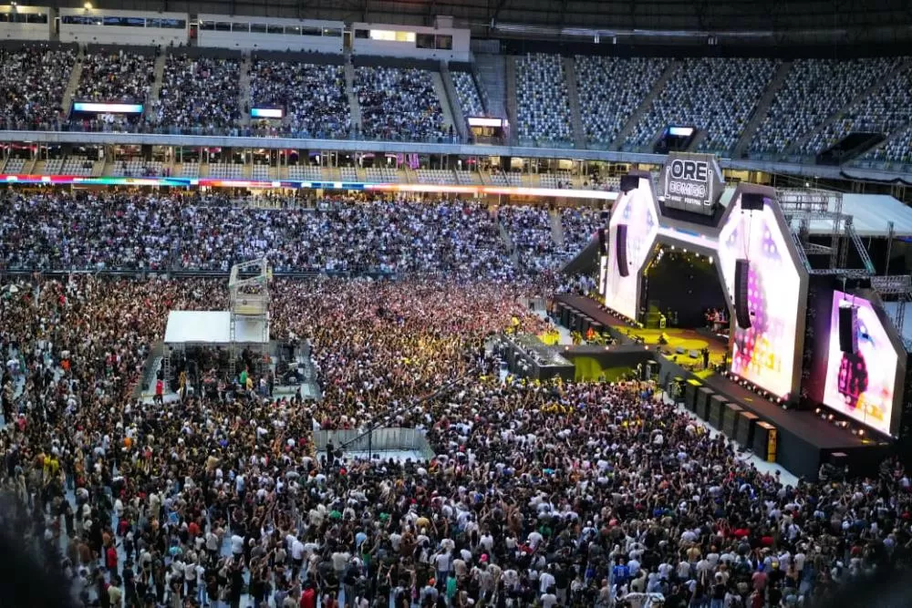 Multidão em estádio durante festival de música ao vivo.