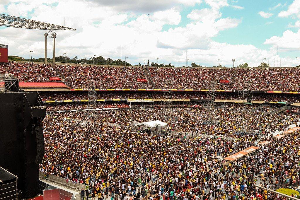 Multidão em estádio durante evento musical.