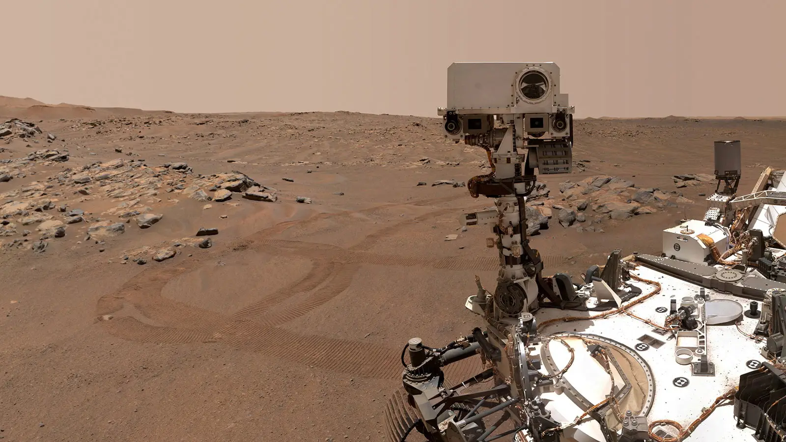 Rover explorando superfície de Marte com solo e rochas.
