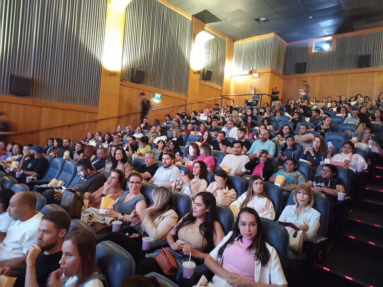 Plateia lotada em sala de cinema, público atento.